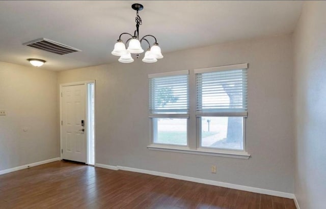 interior space with dark wood-style floors, baseboards, visible vents, and a chandelier