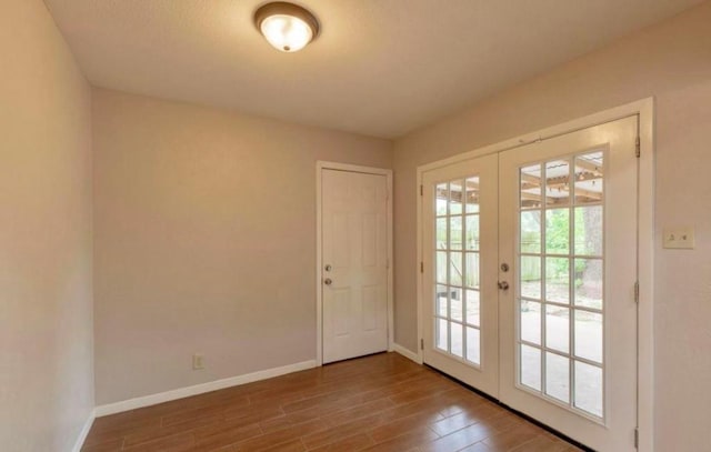 doorway to outside with french doors, baseboards, and wood finished floors