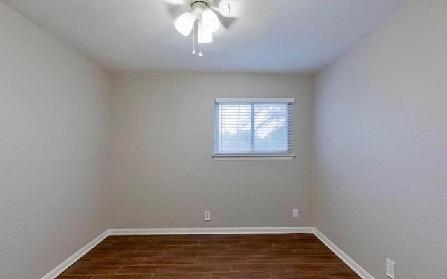 empty room featuring baseboards and dark wood-style flooring