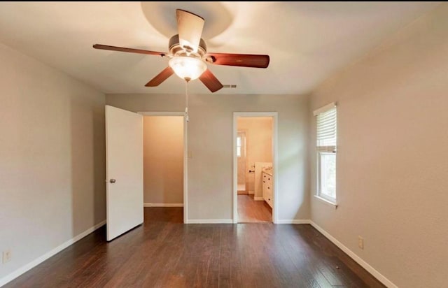 unfurnished bedroom with baseboards, visible vents, hardwood / wood-style flooring, ensuite bath, and ceiling fan