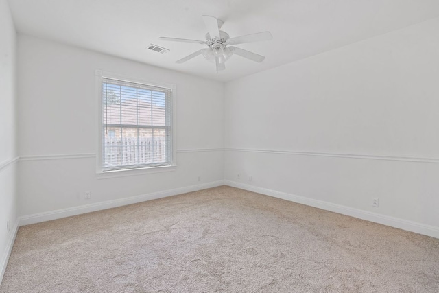 empty room featuring carpet floors, visible vents, ceiling fan, and baseboards