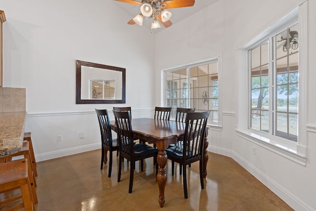 dining area with ceiling fan, baseboards, and concrete flooring