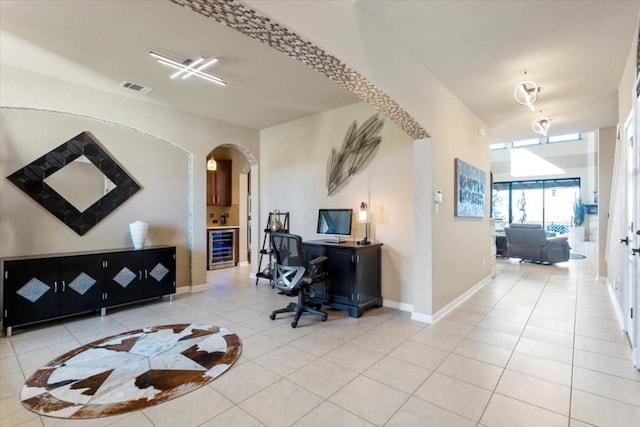 office area with arched walkways, beverage cooler, light tile patterned floors, and visible vents