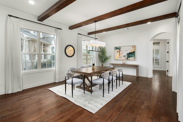 dining area with arched walkways, dark wood-type flooring, beam ceiling, and baseboards