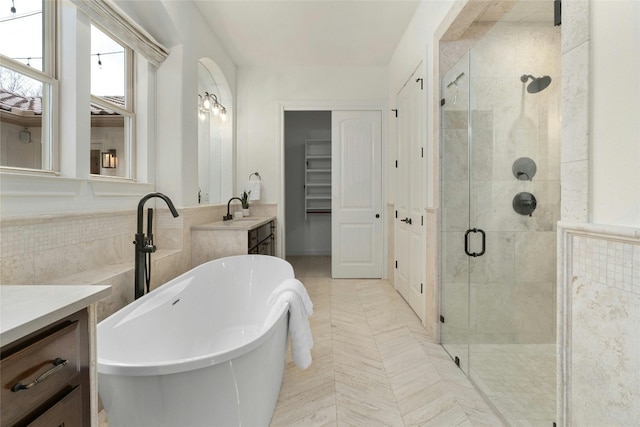 bathroom featuring a freestanding bath, a shower stall, and vanity