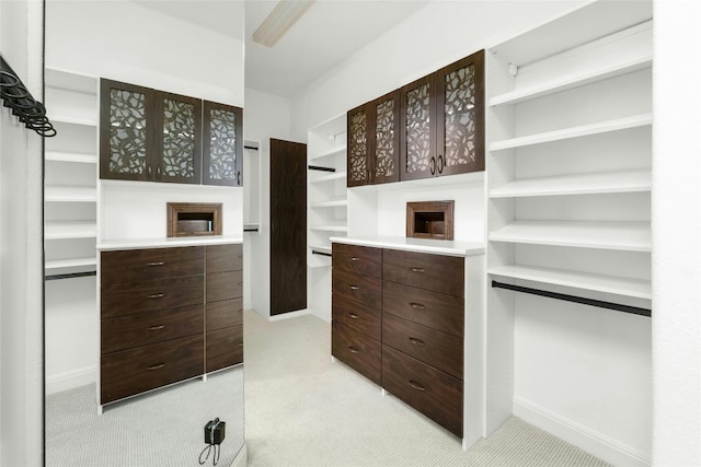 walk in closet featuring light carpet