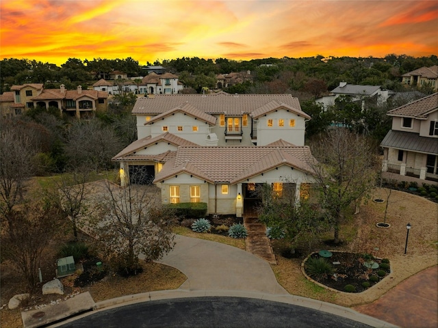 mediterranean / spanish-style home with concrete driveway and a tiled roof