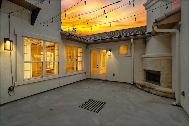 view of patio featuring french doors and exterior fireplace