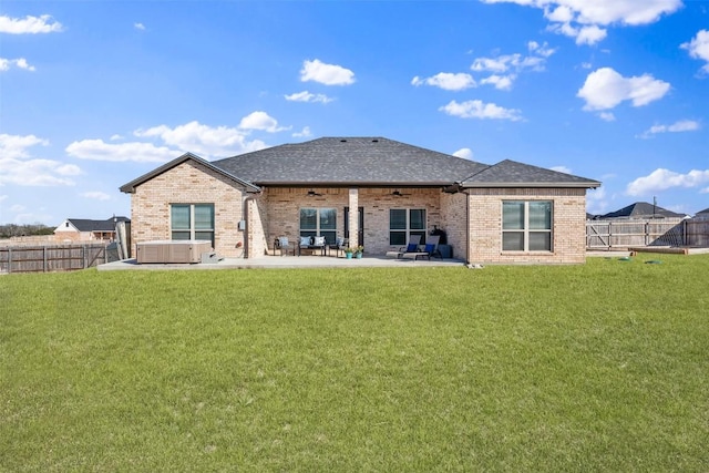 rear view of house featuring ceiling fan, a patio area, a fenced backyard, and a hot tub