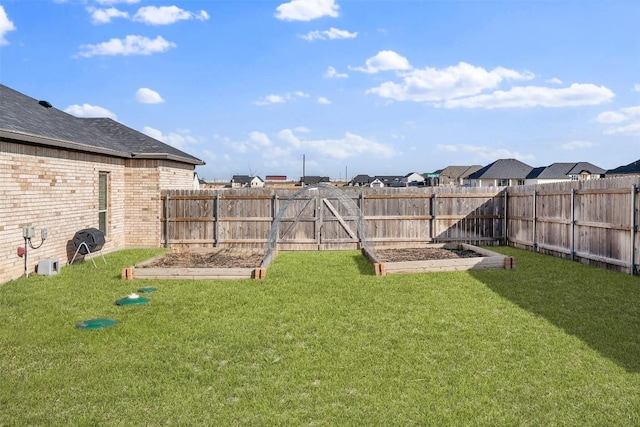 view of yard featuring a fenced backyard and a garden