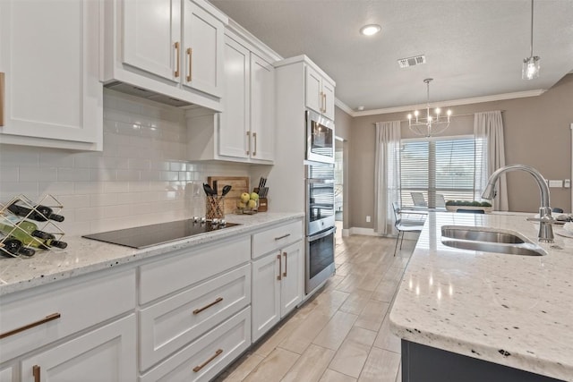 kitchen featuring black electric stovetop, a sink, white cabinetry, visible vents, and crown molding