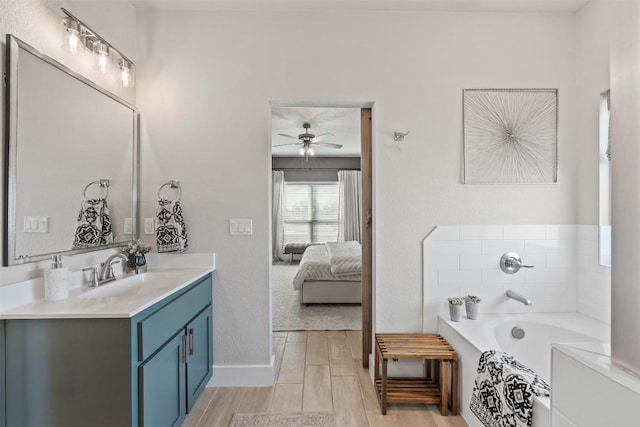 7701 Soapstone Ct, Temple, TX 76502 - bathroom featuring ceiling fan, vanity, a garden tub, wood finished floors, and ensuite bath
