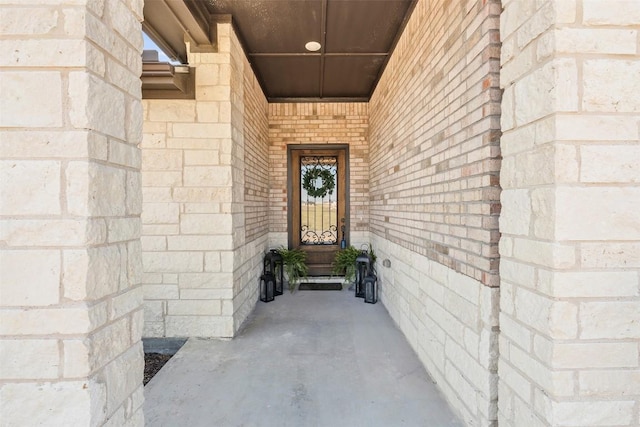 property entrance featuring stone siding and brick siding