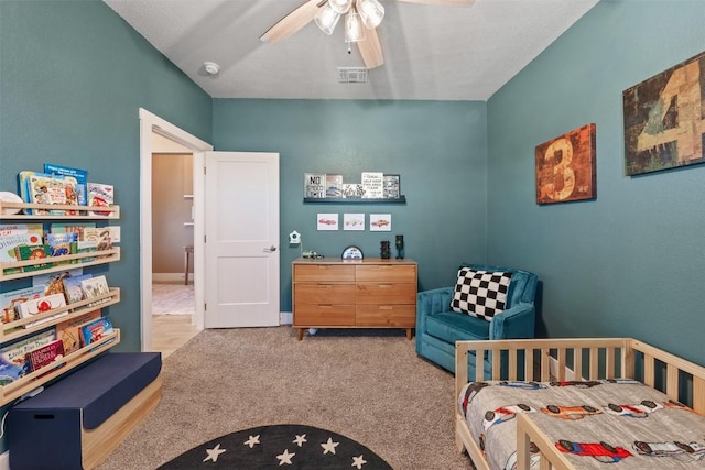 carpeted bedroom featuring a ceiling fan and visible vents