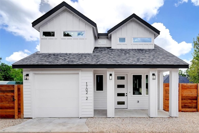 modern inspired farmhouse featuring board and batten siding, a shingled roof, and fence