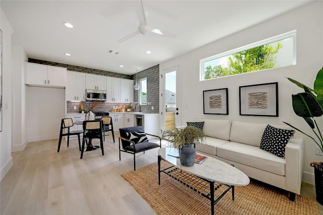 living room with ceiling fan, recessed lighting, visible vents, baseboards, and light wood-style floors