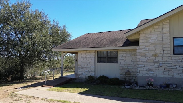 view of property exterior with stone siding, a shingled roof, and board and batten siding