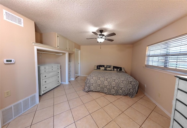 bedroom featuring visible vents, ceiling fan, baseboards, and light tile patterned flooring