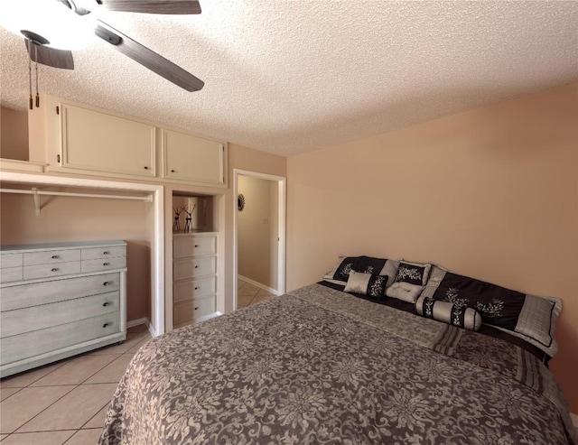 bedroom featuring ceiling fan, a textured ceiling, and light tile patterned flooring