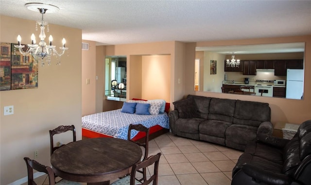 living area featuring visible vents, a notable chandelier, a textured ceiling, and light tile patterned floors