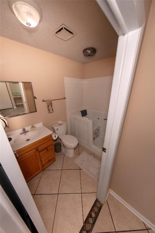 bathroom featuring toilet, vanity, tile patterned flooring, and visible vents