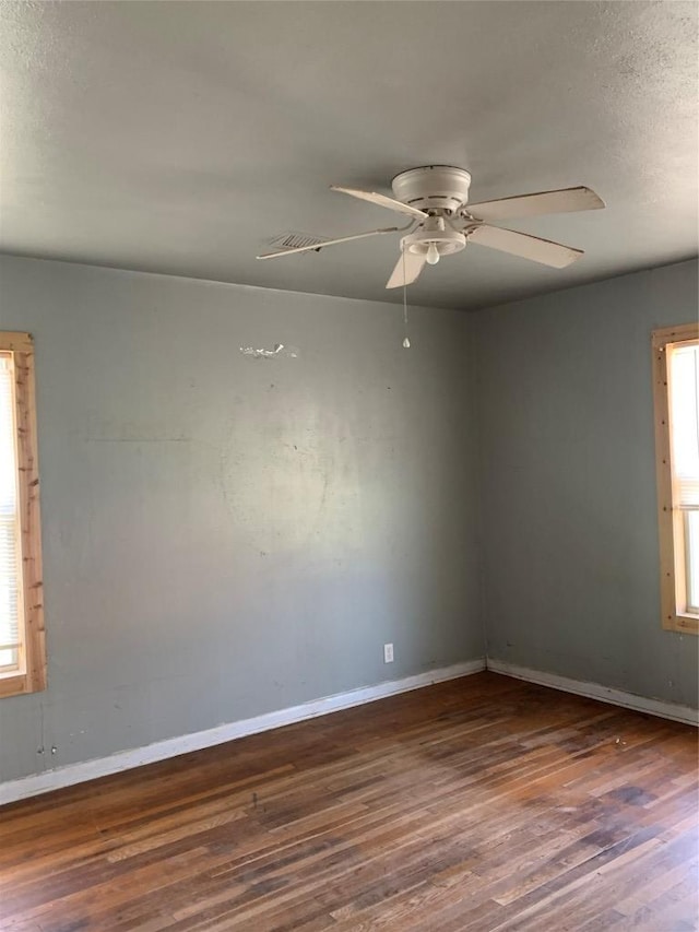 unfurnished room featuring wood finished floors, a ceiling fan, and baseboards