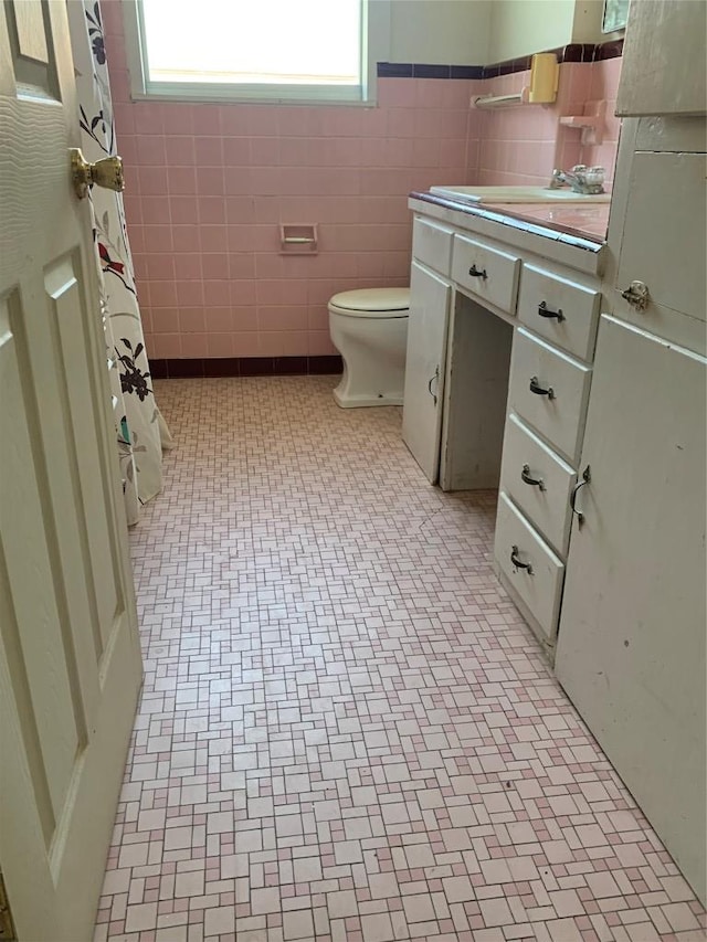 bathroom featuring tile walls, curtained shower, vanity, and toilet