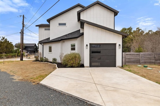 view of front of house with driveway, an attached garage, fence, and a shingled roof