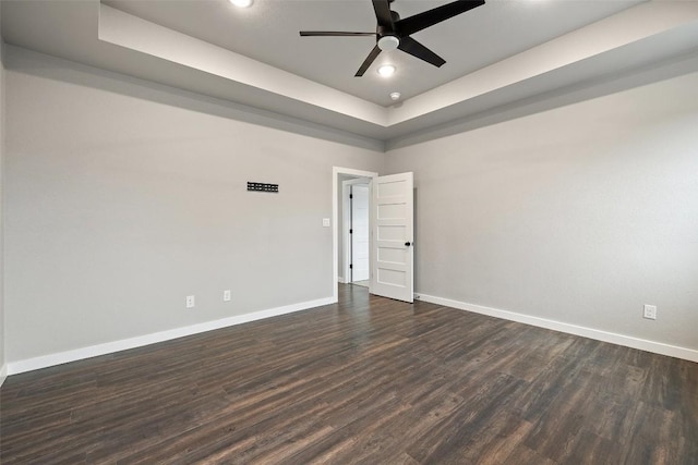 unfurnished room with baseboards, a raised ceiling, ceiling fan, dark wood-style flooring, and recessed lighting