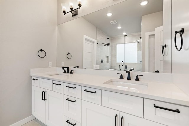 full bathroom featuring double vanity, a stall shower, a sink, and visible vents