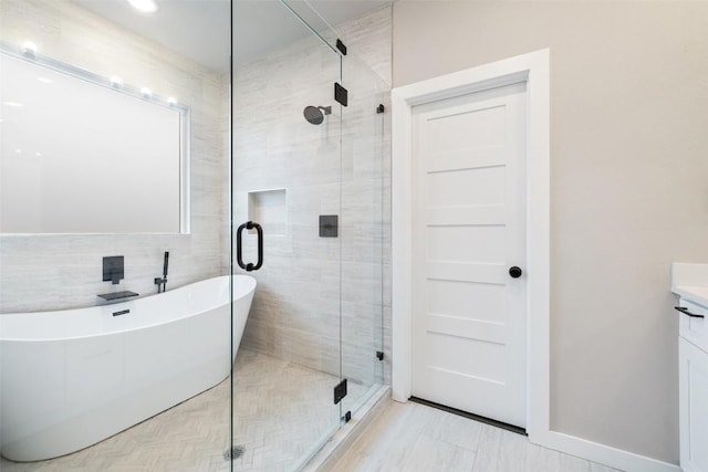 bathroom featuring a freestanding bath, a stall shower, and vanity