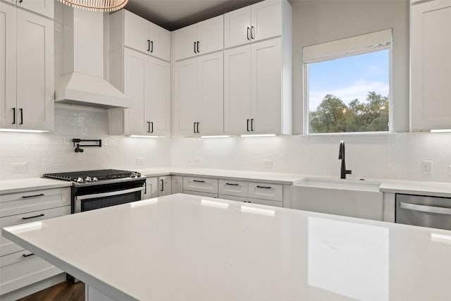 18200 Fair Ln, Jonestown, TX 78645 - kitchen with wall chimney range hood, a sink, stainless steel appliances, light countertops, and backsplash