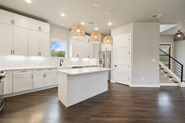 18200 Fair Ln, Jonestown, TX 78645 - kitchen with stainless steel refrigerator with ice dispenser, a kitchen island, dark wood finished floors, white cabinetry, and light countertops