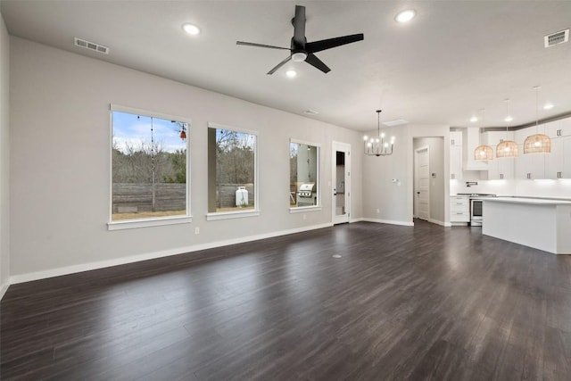 unfurnished living room with ceiling fan with notable chandelier, visible vents, dark wood finished floors, and recessed lighting