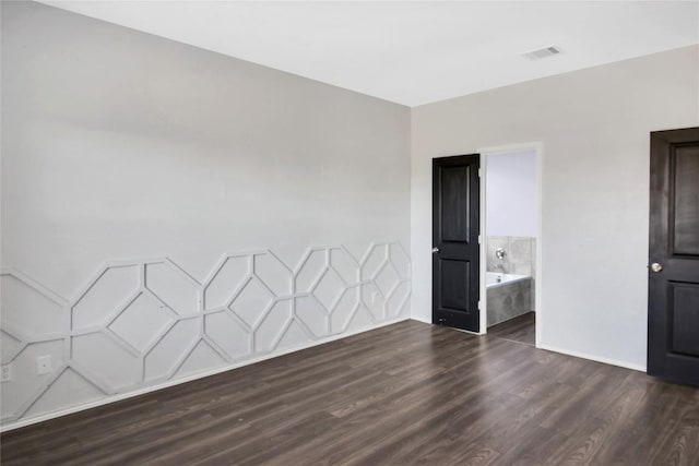 unfurnished room featuring visible vents and dark wood-type flooring