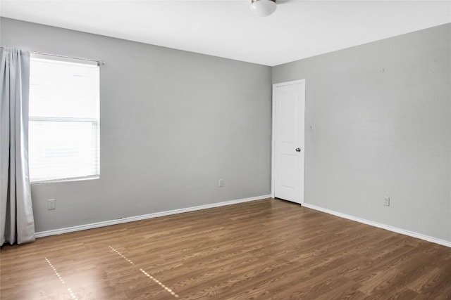 spare room featuring wood finished floors and baseboards