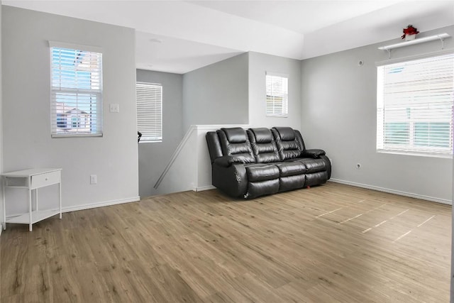 living area with baseboards and wood finished floors