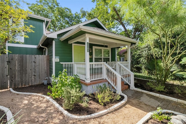 view of front of home with a porch and fence