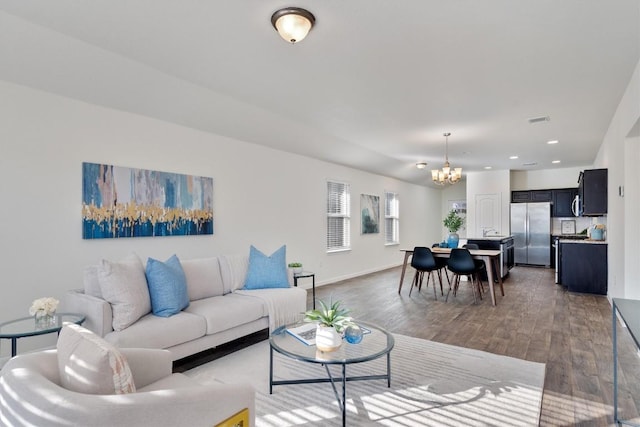 living room with baseboards, visible vents, wood finished floors, a chandelier, and recessed lighting