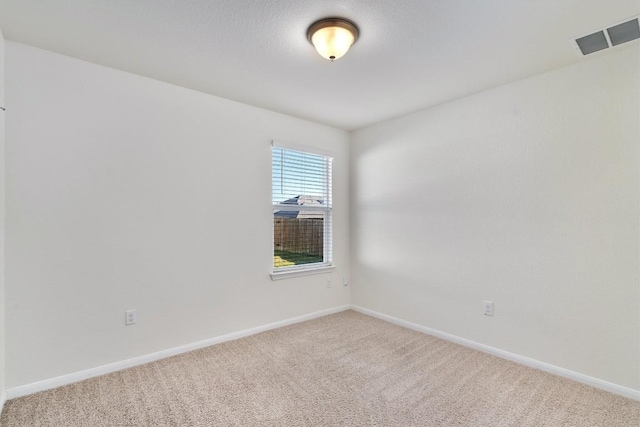 carpeted spare room with baseboards and visible vents