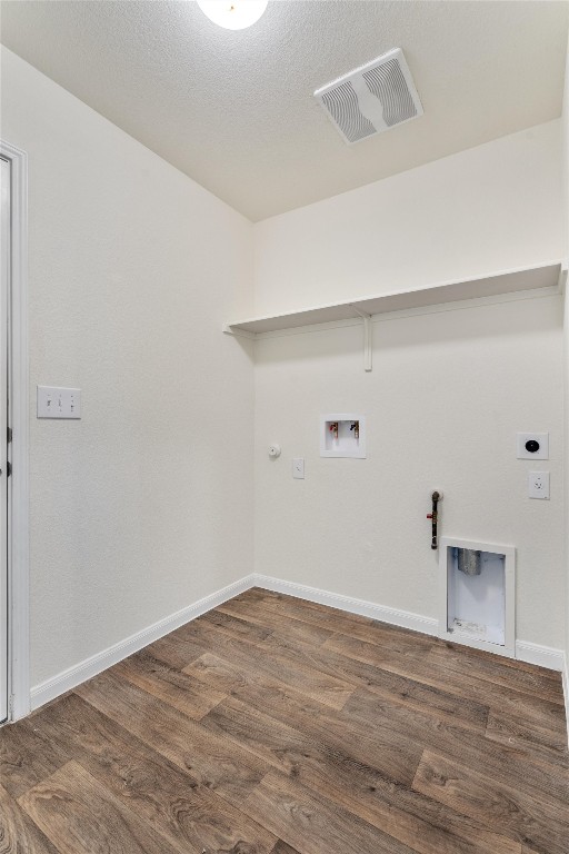 clothes washing area with hookup for a washing machine, hookup for a gas dryer, visible vents, wood finished floors, and laundry area