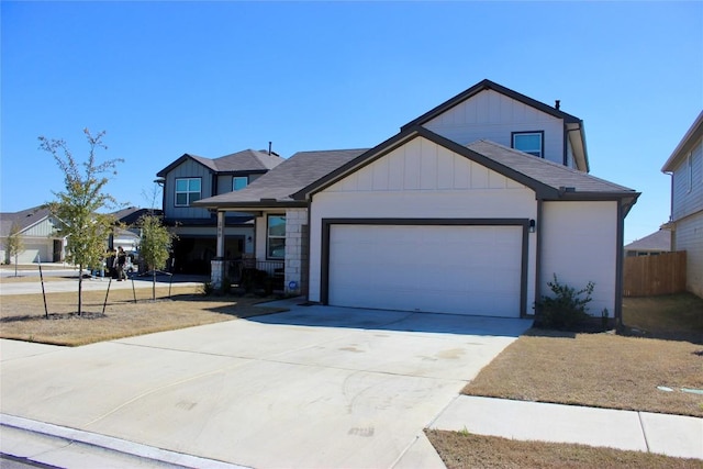 view of front of home featuring board and batten siding, driveway, an attached garage, and fence