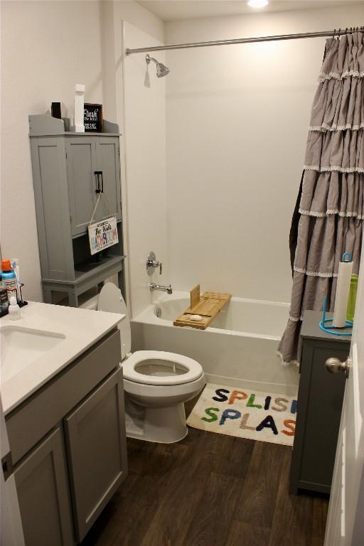 full bathroom featuring vanity, wood finished floors, bathtub / shower combination, and toilet