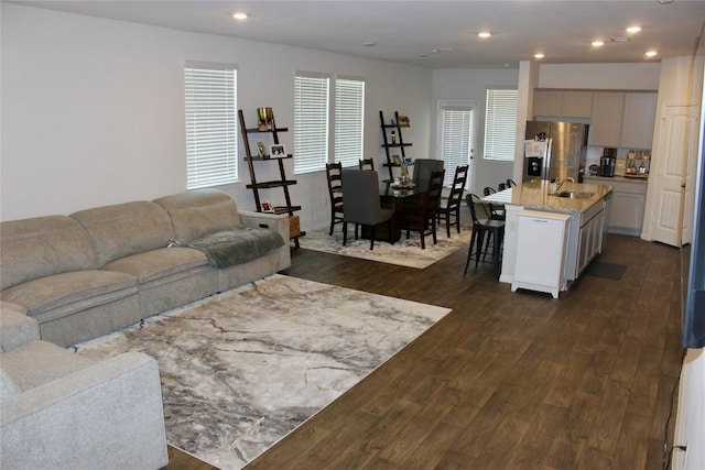 living area with dark wood-style flooring and recessed lighting