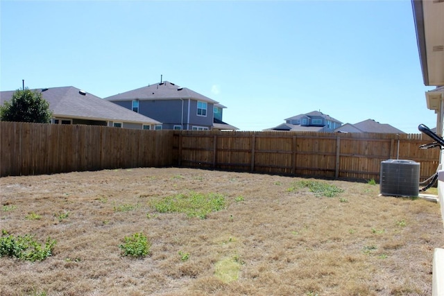 view of yard with central AC unit and fence