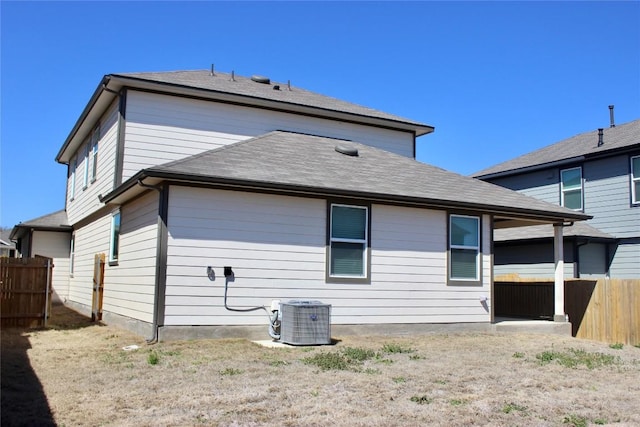 back of house with fence and central AC