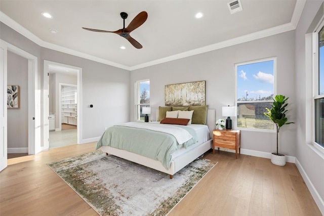 bedroom with ornamental molding, light wood-type flooring, visible vents, and baseboards