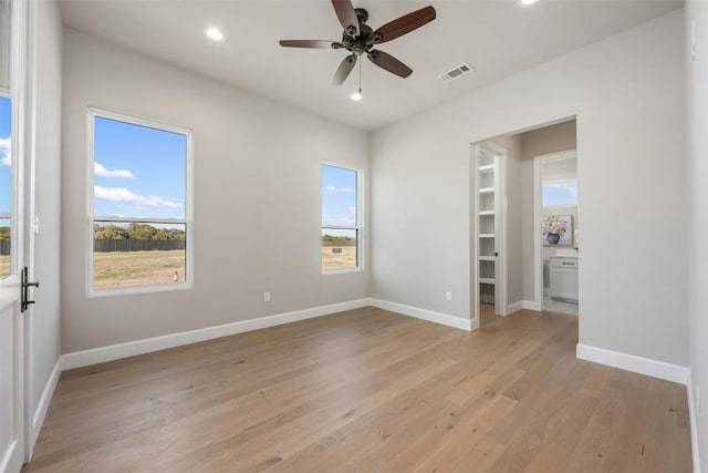 empty room featuring baseboards, light wood-type flooring, visible vents, and recessed lighting