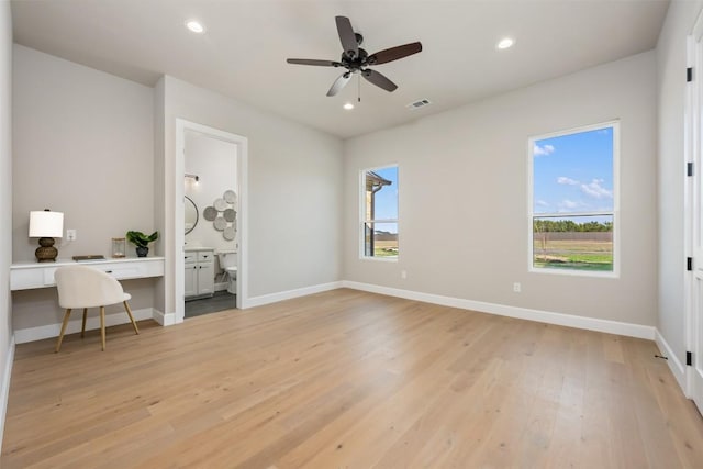 office with baseboards, visible vents, light wood-style floors, built in desk, and recessed lighting