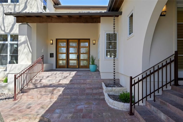 entrance to property featuring french doors and stucco siding